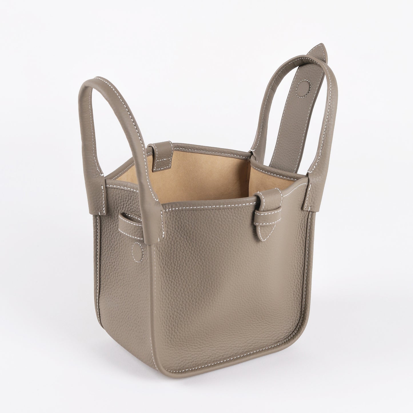 Beige leather bucket bag with handles on a white background