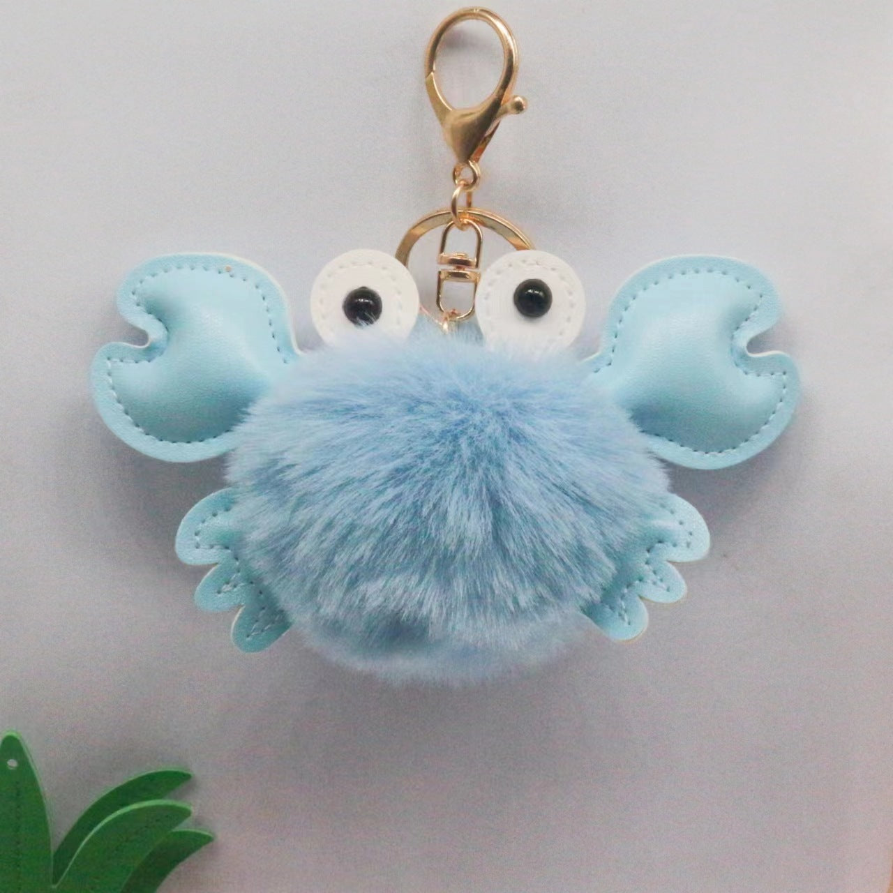 Blue crab-shaped keychain with a fluffy body