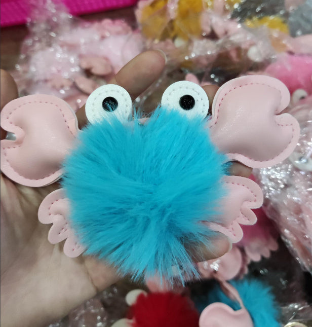 Blue fuzzy ball with pink heart-shaped ears held