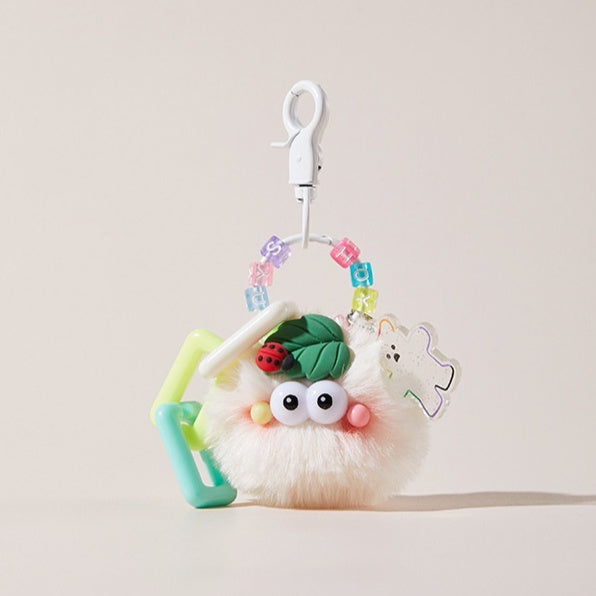 Blush ladybug keychain hanging on a purse