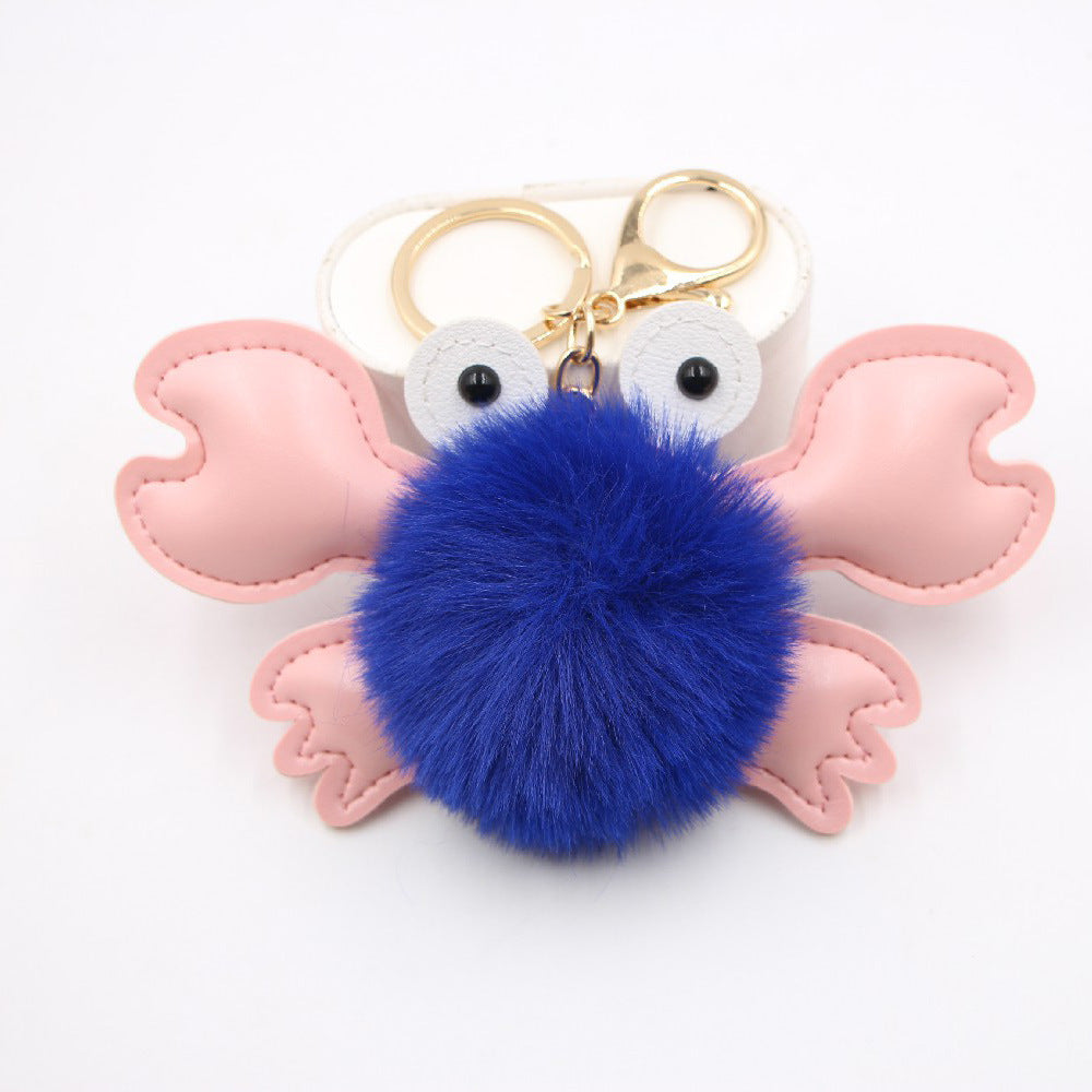 Crab-shaped keychain with a blue pom-pom