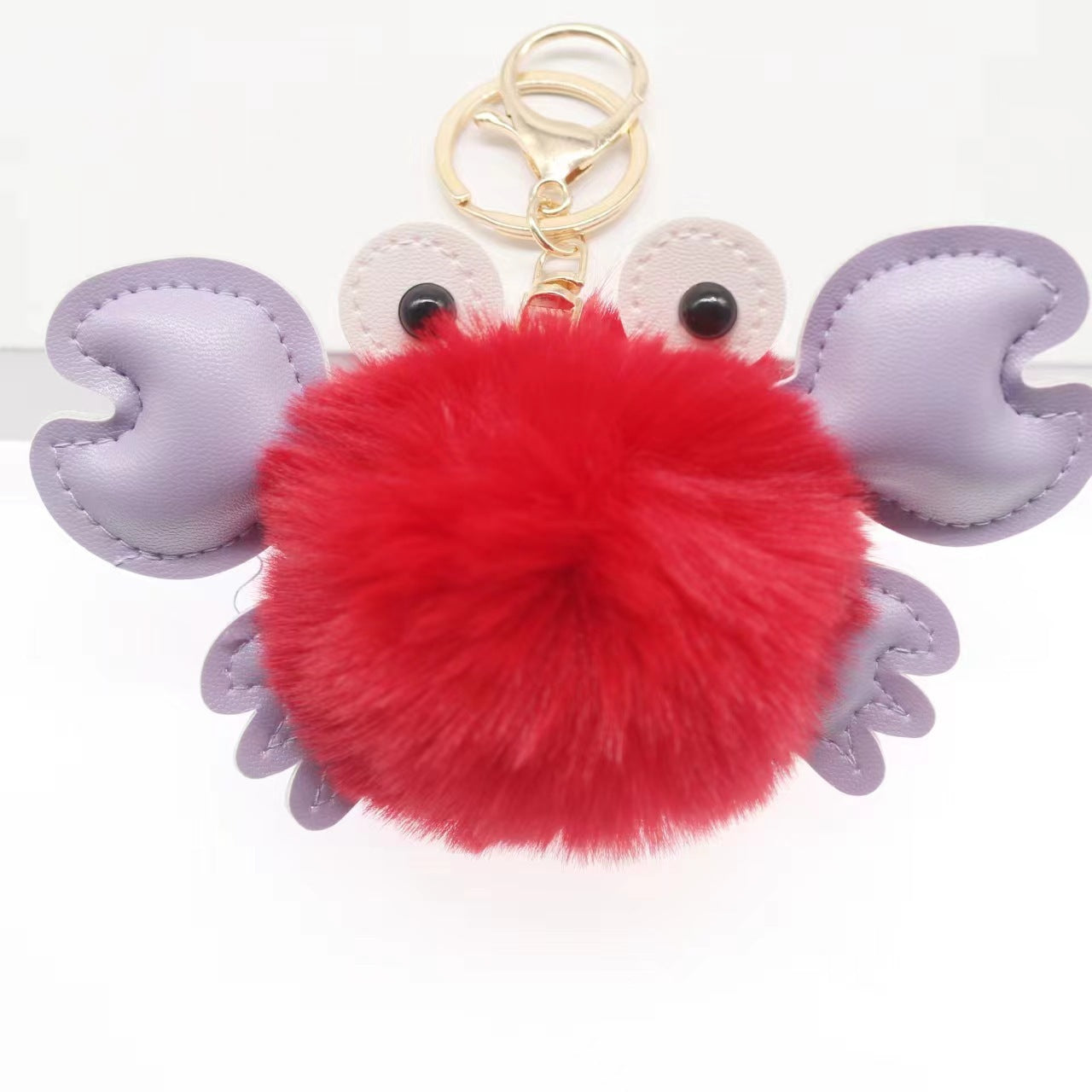 Crab-shaped keychain with red pom-pom