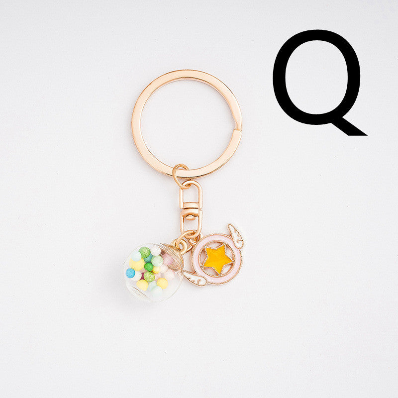 Gold keychain with colorful charms on a white background