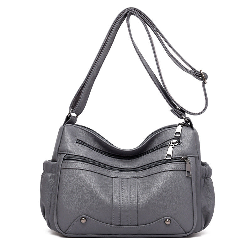 Gray handbag with a shoulder strap on a white background