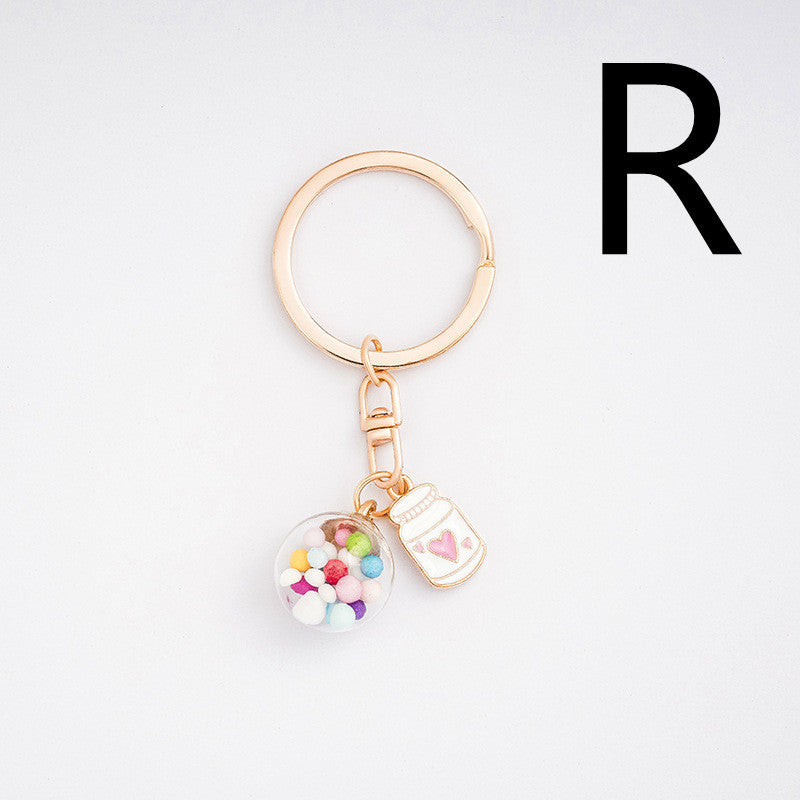 Keychain with colorful charm and letter 'R' on a light gray background