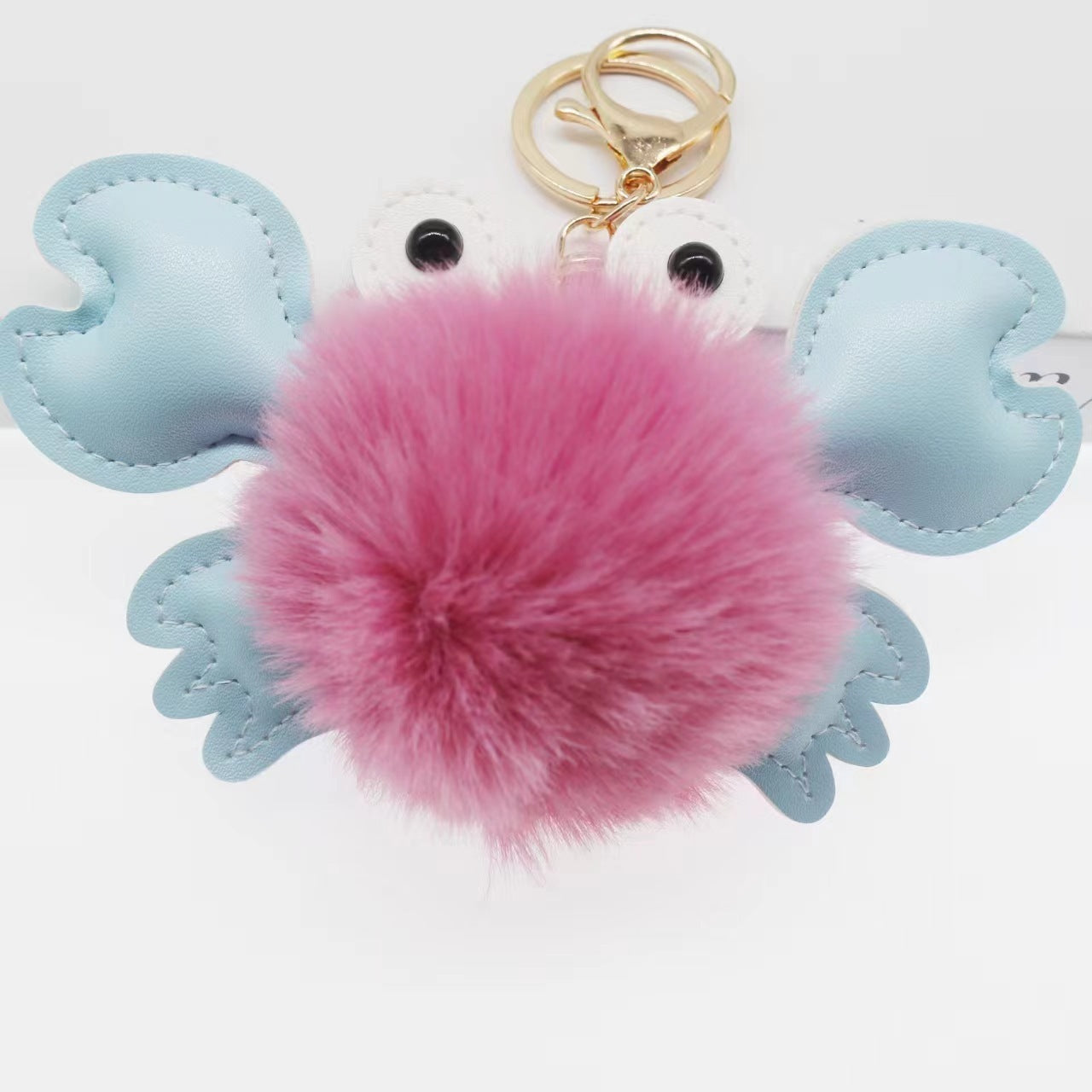 Keychain with pink fluffy ball and blue heart-shaped wings