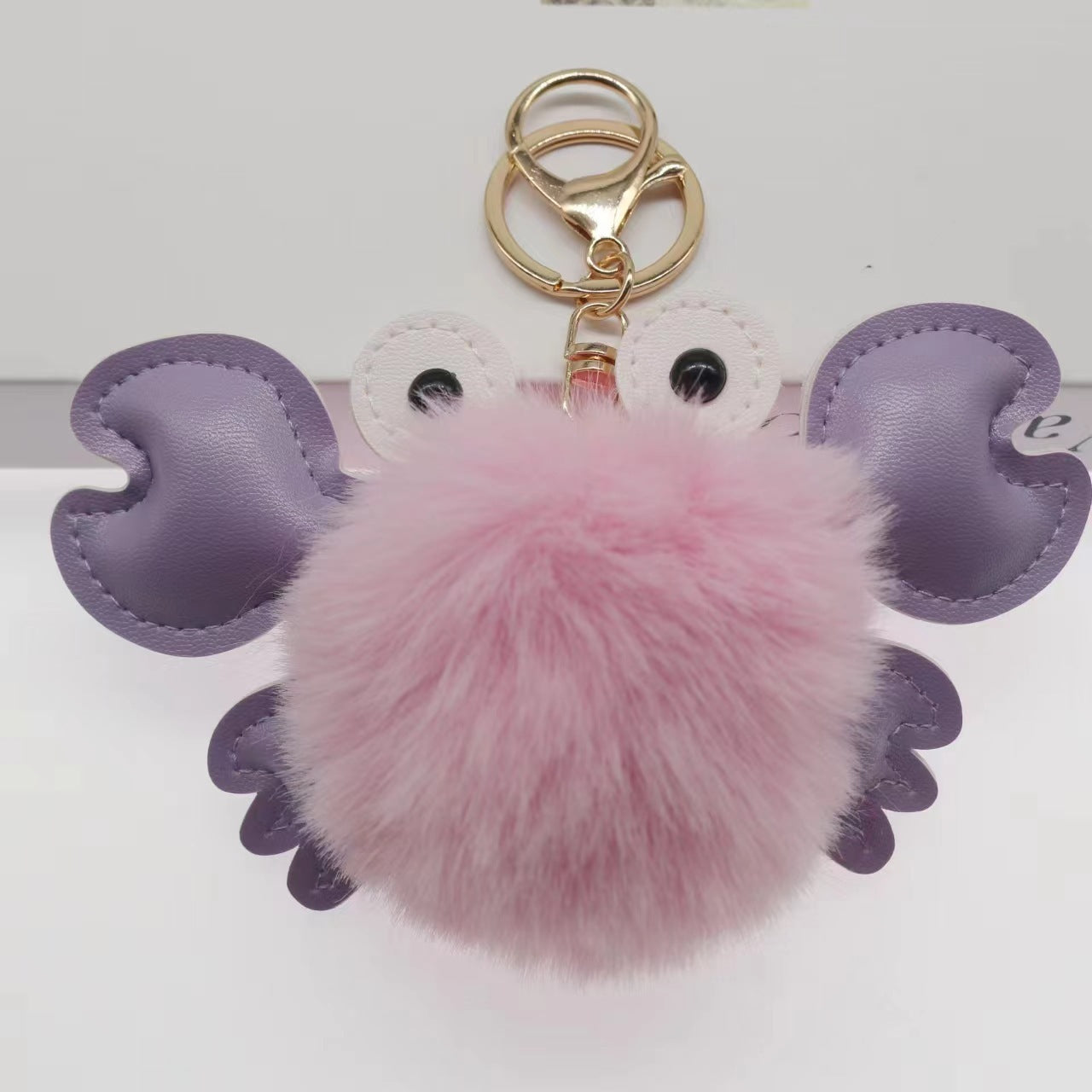 Keychain with pink fluffy ball and purple wings