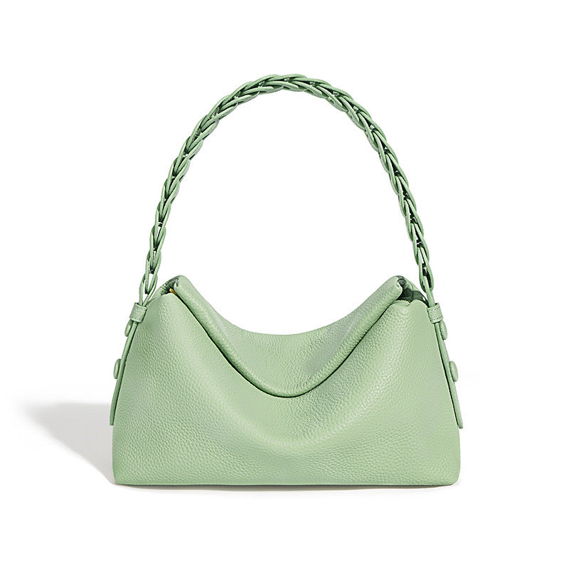 Light green handbag with braided handle on a white background