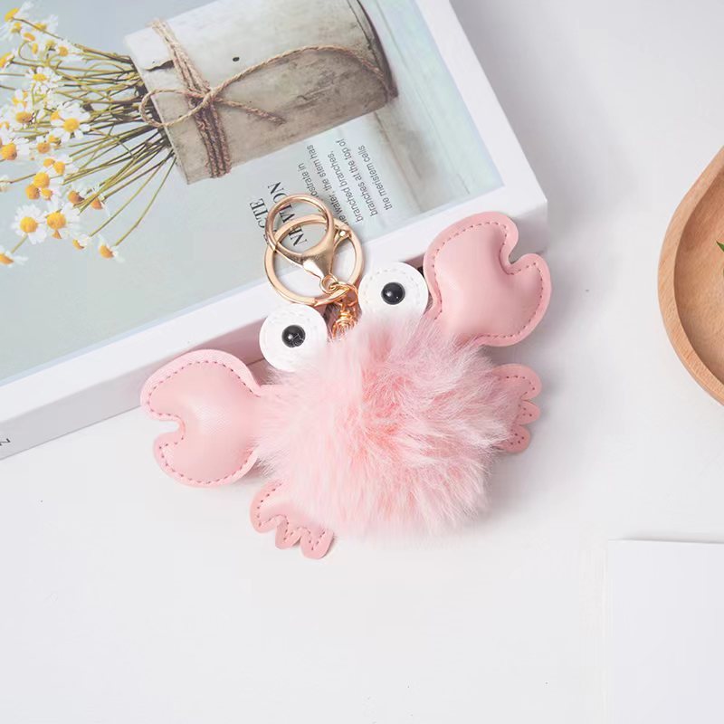 Pink crab-shaped keychain with a fluffy tail