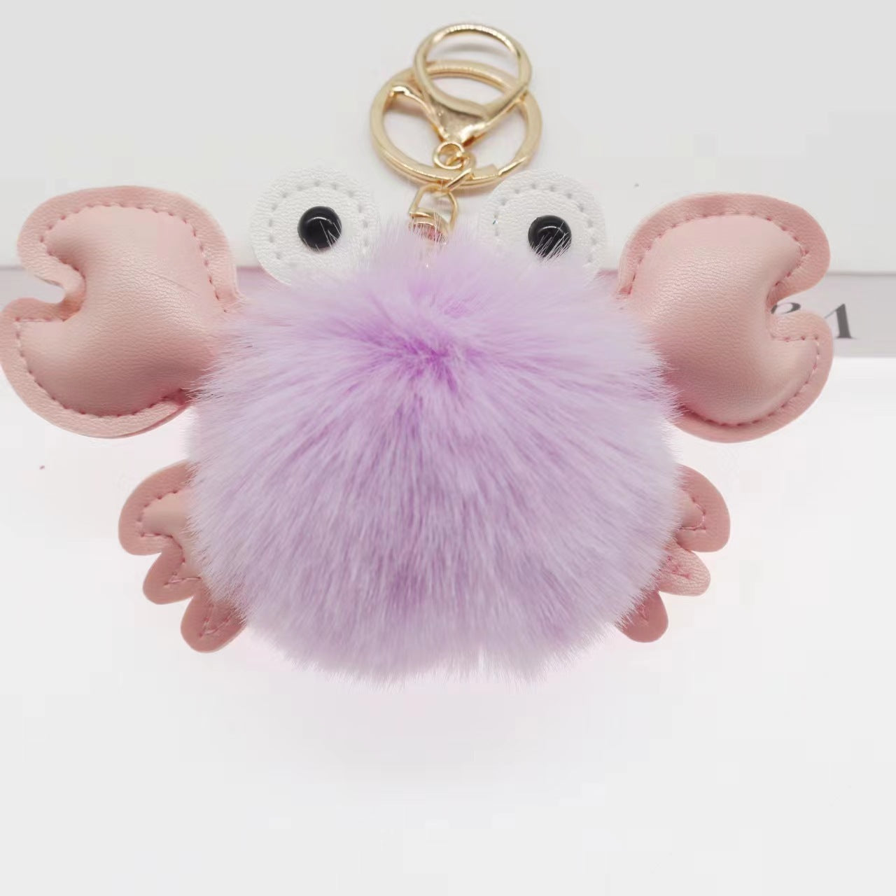 Pink mouse-shaped keychain with a purple pom-pom