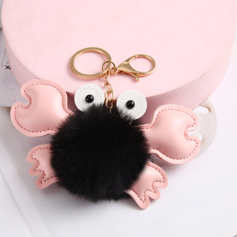 Pink owl-shaped keychain with a black pom-pom