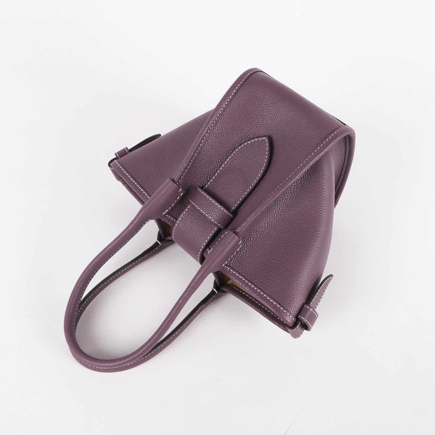 Purple handbag with a bow detail on a white background