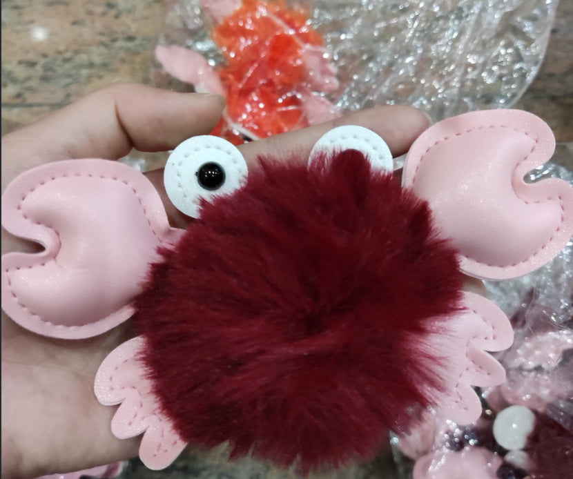 Red fuzzy ball with pink heart-shaped wings held