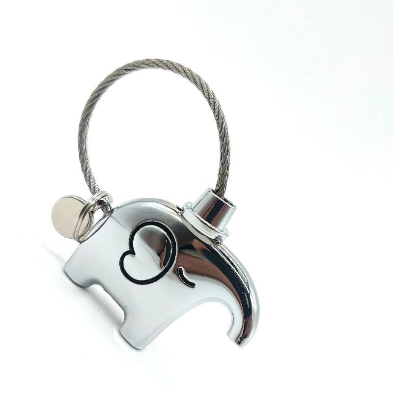 Silver elephant-shaped keychain with a heart design on a white background