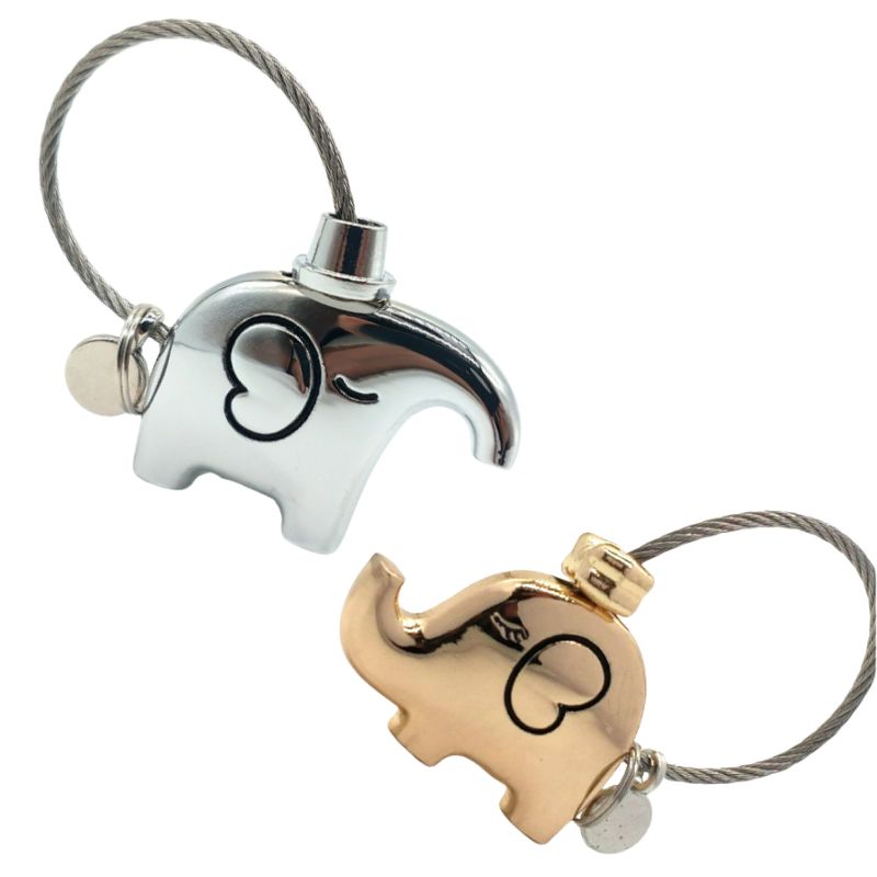 Silver and gold elephant-shaped keychains on a white background