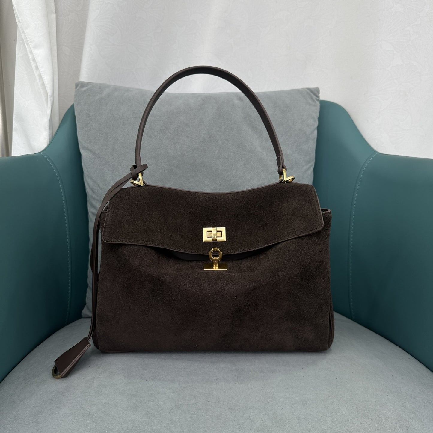 Model carrying caramel leather crossbody commuter bag