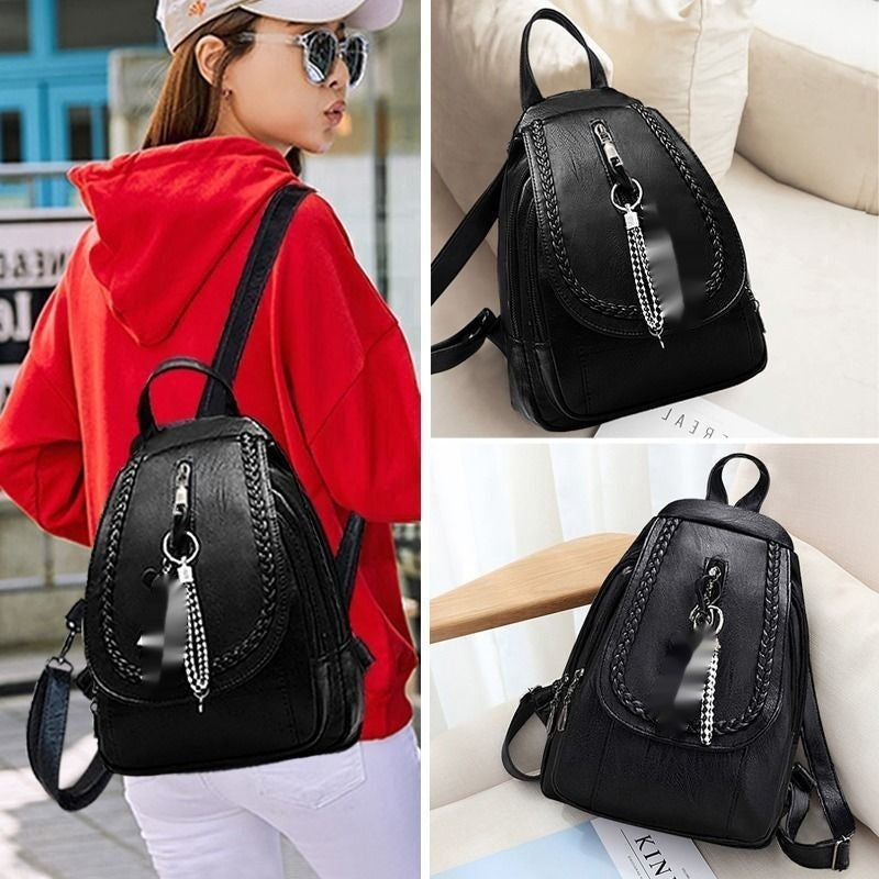 Black backpack with decorative chain on a person and a surface