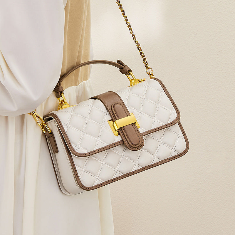 Close-up of clamshell closure on compact leather bag