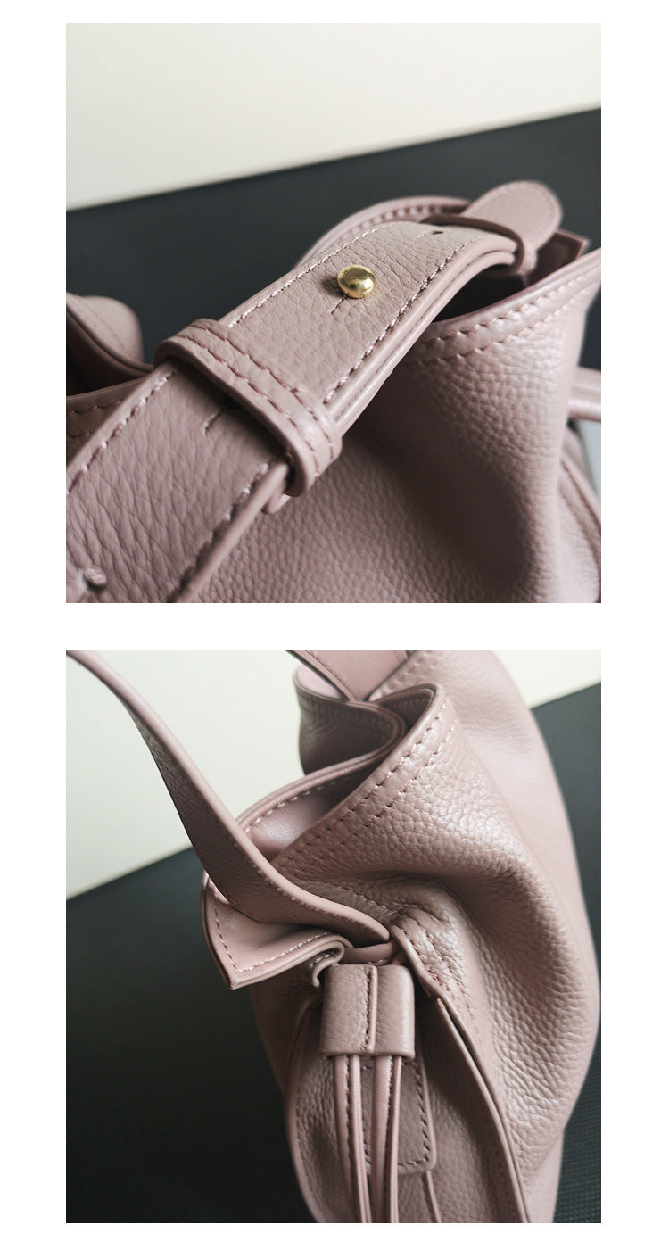 Side angled view of burgundy cowhide pull-belt crossbody bucket bag