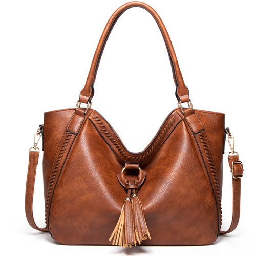Brown leather handbag with tassel on a white background