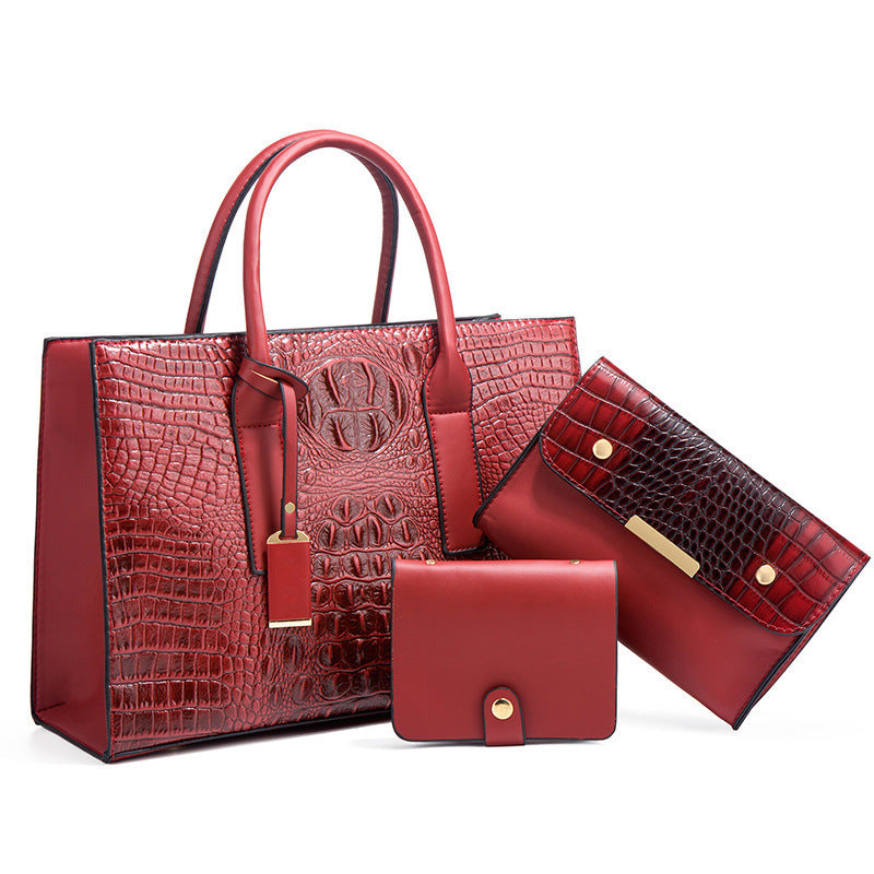Three-piece women’s PU leather crocodile pattern handbag set on white background