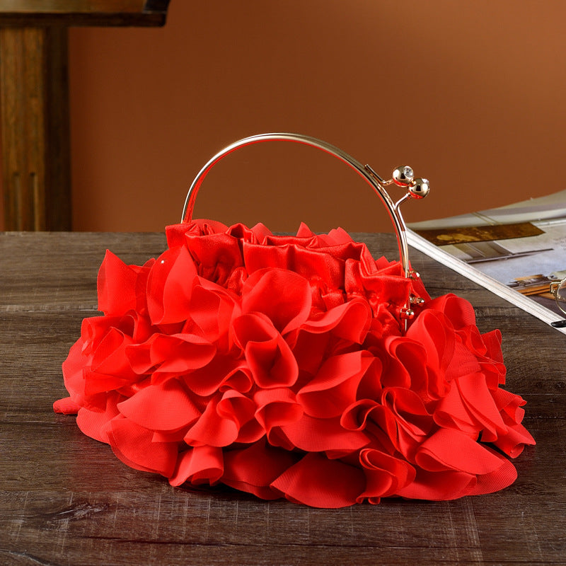 Red floral handbag on a wooden surface with a blurred background