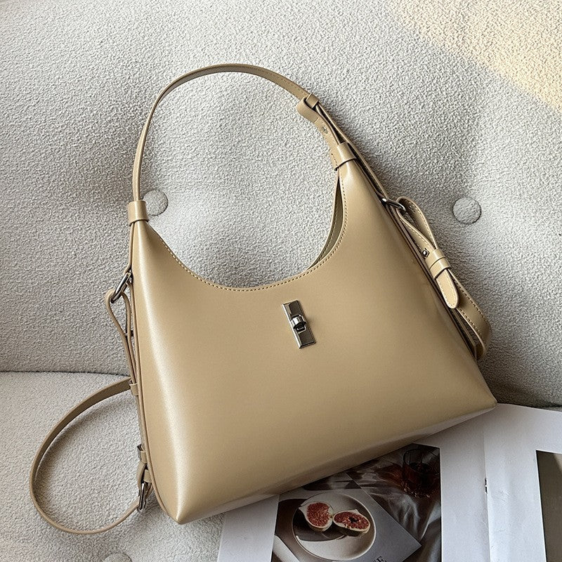 Brown cowhide leather bag with lock and sewing thread detail