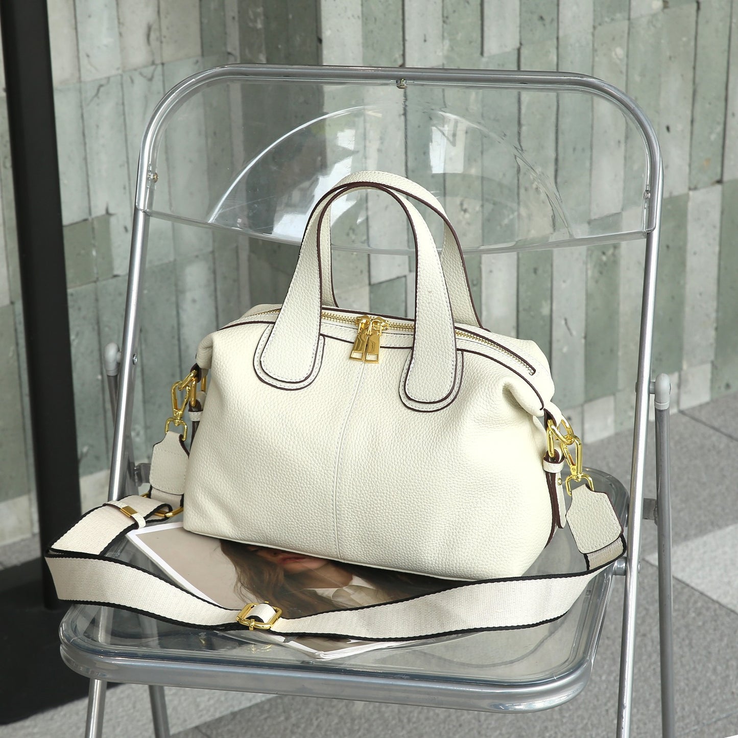 Woman holding square cowhide leather shoulder bag