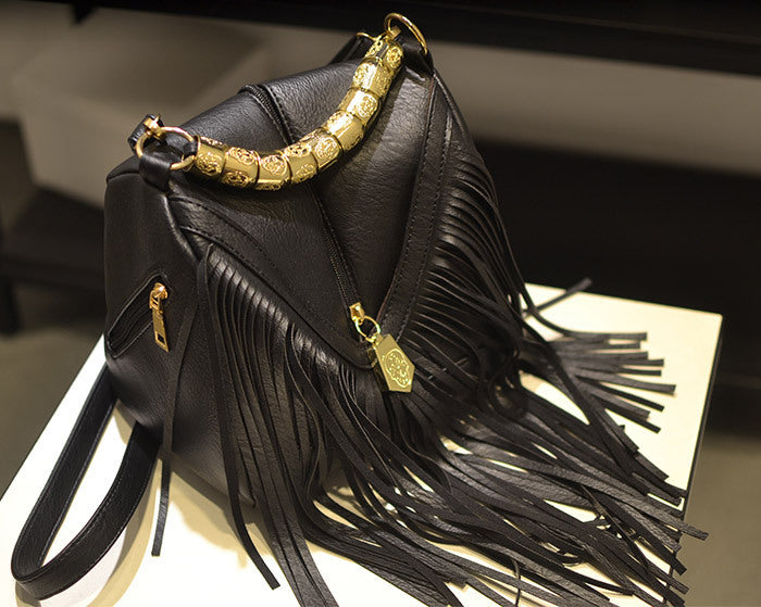 Black oval-shaped crossbody purse with tassel