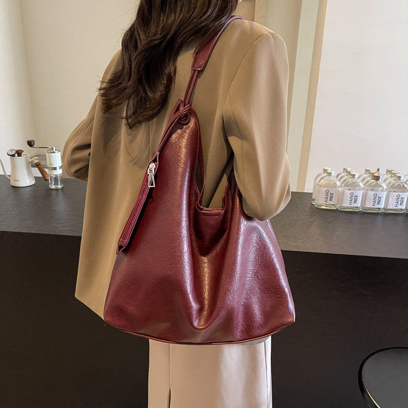 Person holding a red handbag in an indoor setting