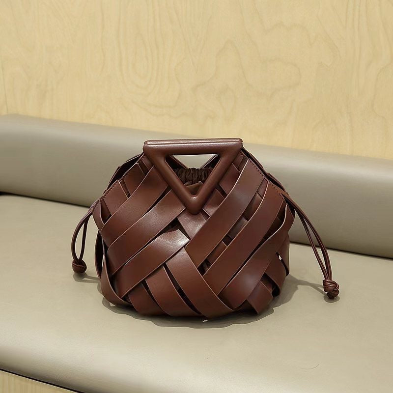 Leather bucket bag with triangle top shown on display stand