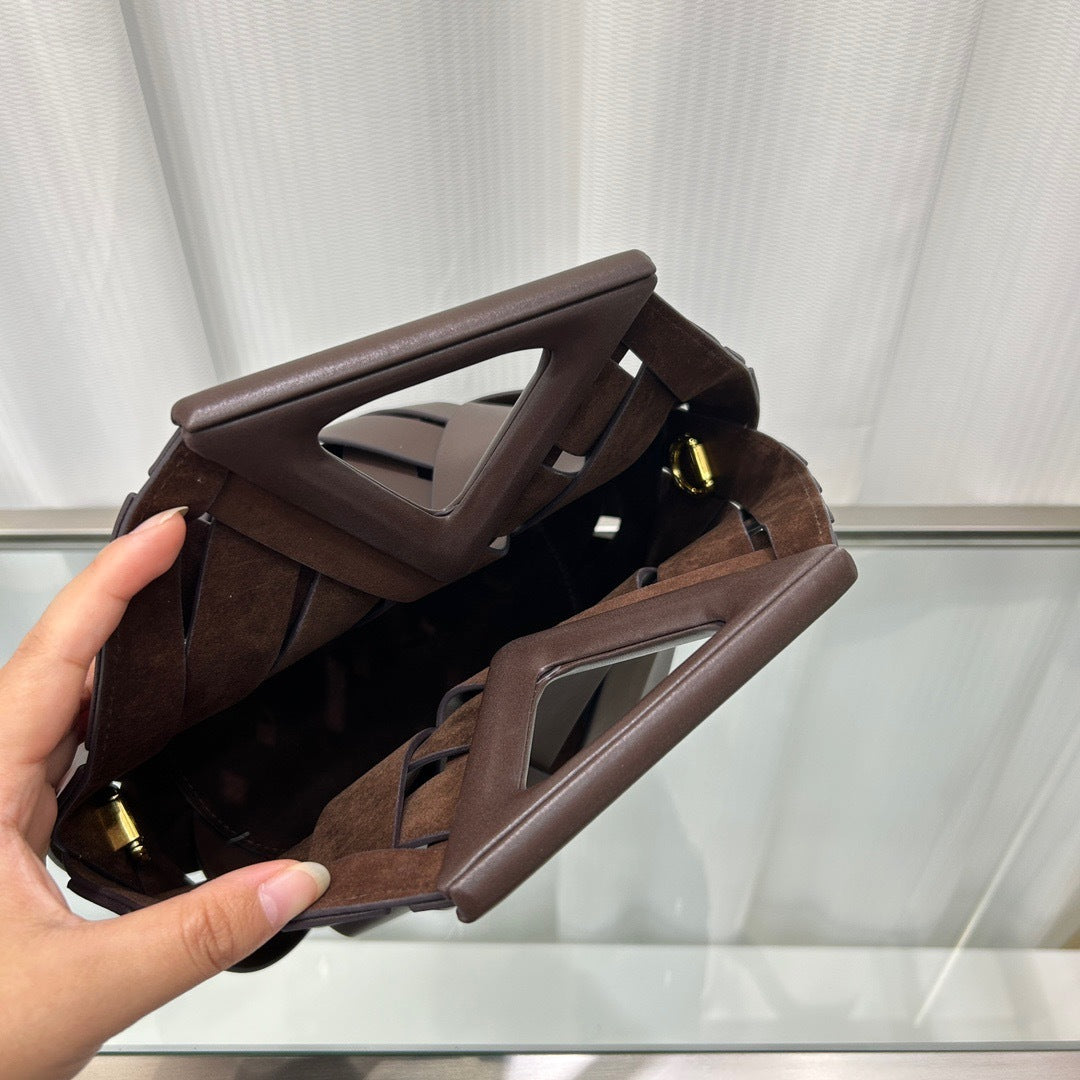 Side profile view of leather triangle crossbody bag with structured shape