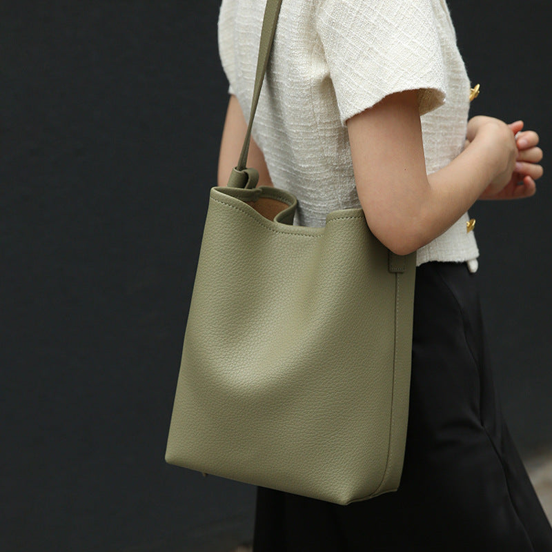 Size comparison of leather crossbody bucket bag next to personal items