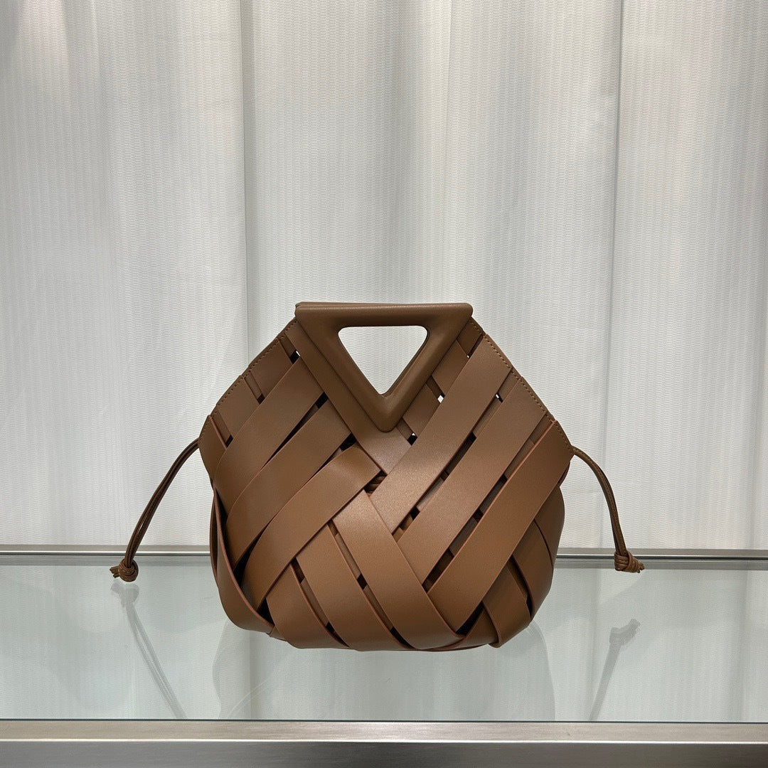 Woman carrying triangle magnetic buckle leather handbag on shoulder