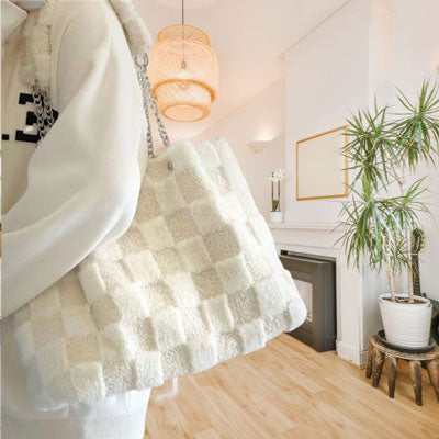 Side profile of white plush faux wool tote bag