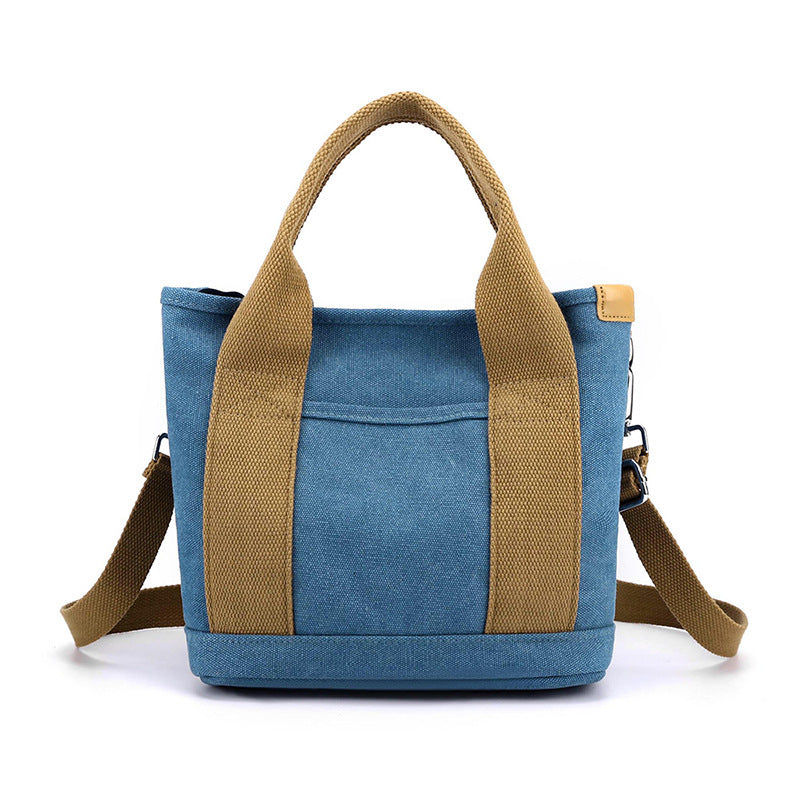 Blue tote bag with brown handles and straps on a white background