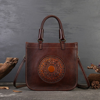 Brown leather handbag with decorative circular pattern on a gray background