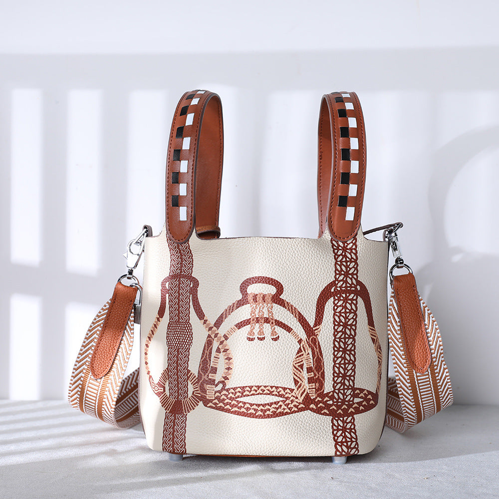 Handbag with brown leather straps and intricate design on a light background