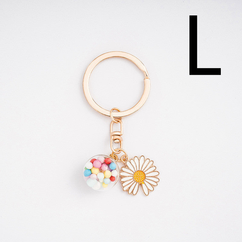 Keychain with heart and flower charm on a light gray background