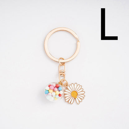 Keychain with heart and flower charm on a light gray background
