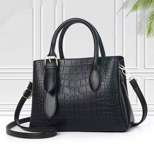 Black crocodile-patterned handbag with a matching strap