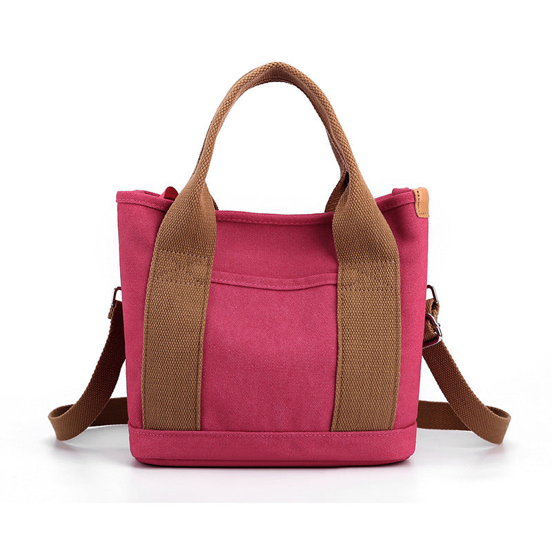 Pink tote bag with brown straps on a white background