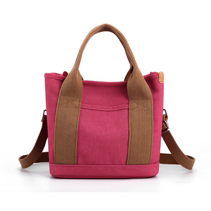 Pink tote bag with brown straps on a white background