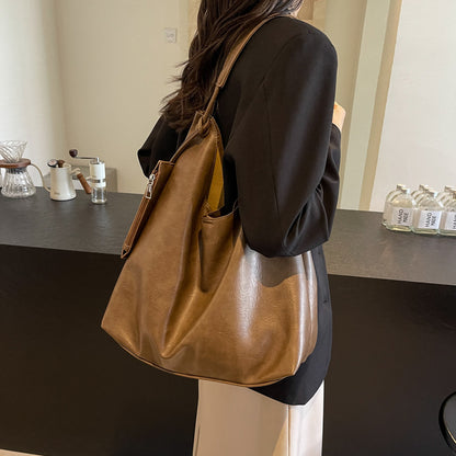 Person holding a brown leather bag in a kitchen setting