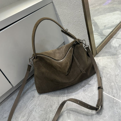 Brown suede handbag on a gray tiled floor