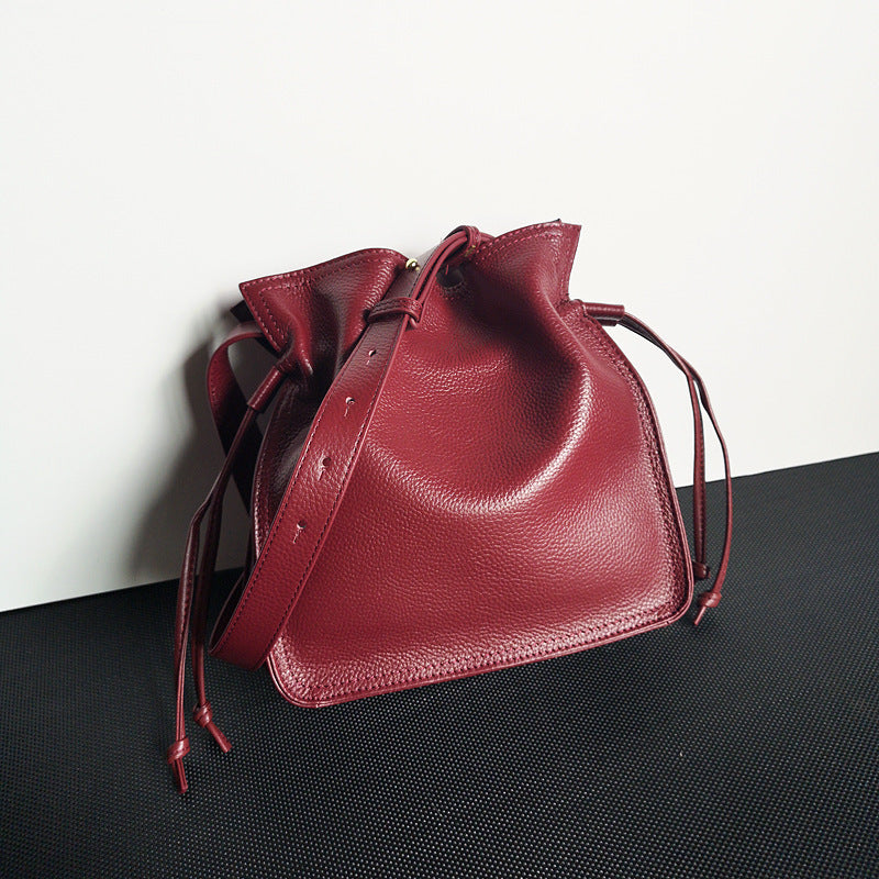 Front view of yellow first layer cowhide pull-belt crossbody bucket bag for women