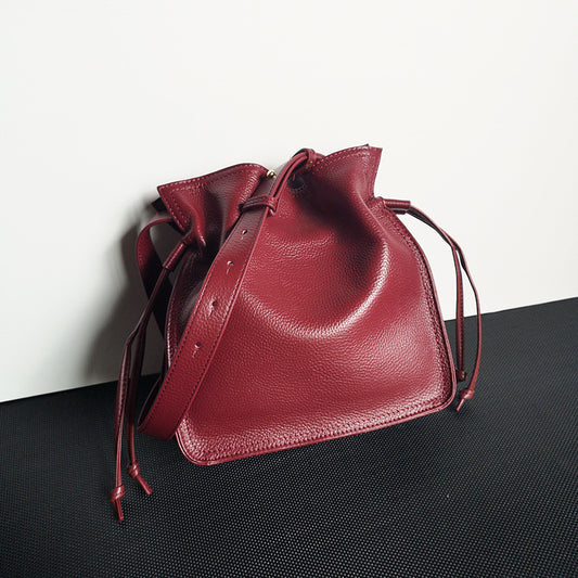 Front view of yellow first layer cowhide pull-belt crossbody bucket bag for women