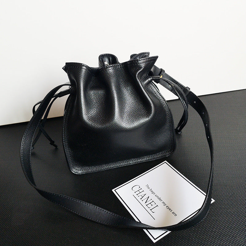 Size comparison showing capacity of pull-belt cowhide crossbody bucket bag