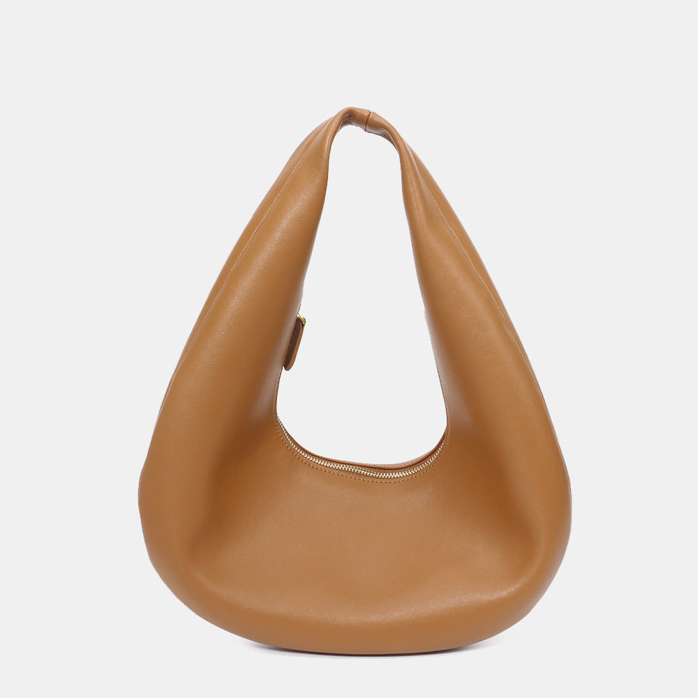 Side view showing thin profile of cowhide shoulder bag