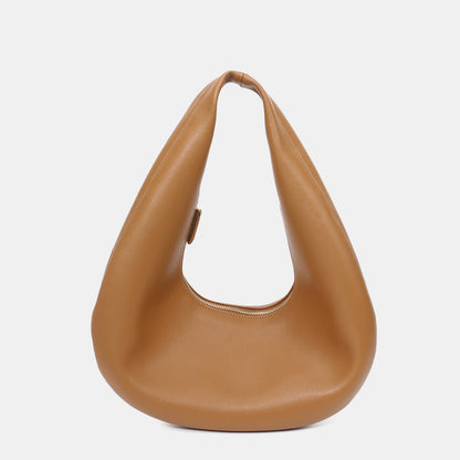 Side view showing thin profile of cowhide shoulder bag